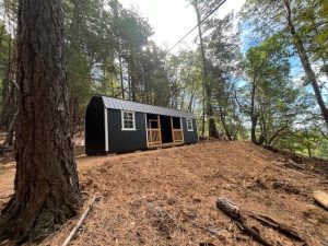 Old Hickory Lofted Center Porch shed with metal roof in scenic wooded hillside setting, portable backyard storage building