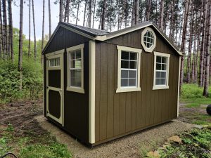 Old Hickory Utility Shed with Gable Dormer, metal roof, multiple windows and single barn door in wooded setting