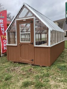 Old Hickory Greenhouse with clear panels and entry door on sales lot, backyard greenhouse ideal for gardening