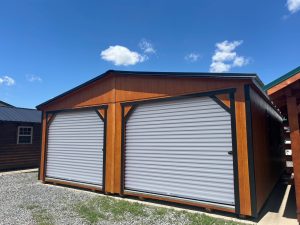 Old Hickory Double Wide Utility Shed with dual roll-up garage doors, black trim and roof on sales lot
