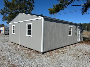 Old Hickory Double Wide Utility Shed with white trim, metal roof, windows and side entry door on sales lot