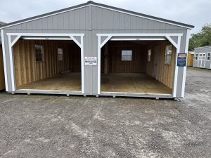 Old Hickory Double Wide Utility Shed with dual roll-up garage door opening and metal roof on sales lot