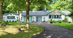 Old Hickory Utility Shed with Gable Dormer, metal roof and windows, portable backyard storage building beside home
