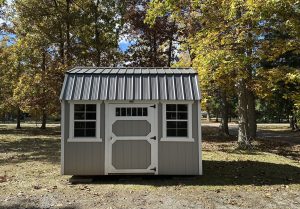 Old Hickory Side Lofted Barn with charcoal metal roof, windows and single barn door, portable backyard storage building in wooded fall property