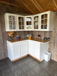 Old Hickory Utility Shed interior with cabinets and countertop workspace, transformed backyard storage shed with custom flooring and siding