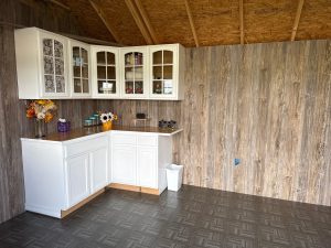 Transformed Old Hickory Utility Shed interior with cabinets, countertop workspace, custom flooring and siding