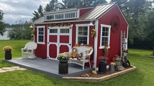 Old Hickory Utility Shed with dormer, porch deck and white trim, stylish backyard storage shed with autumn décor for homes and gardens