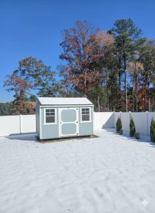 Old Hickory Side Utility storage shed with barn door and windows in snow-filled yard, durable outdoor shed