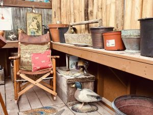 Old Hickory Greenhouse interior with garden pots and chair seating area, cozy backyard greenhouse for gardening and studio use